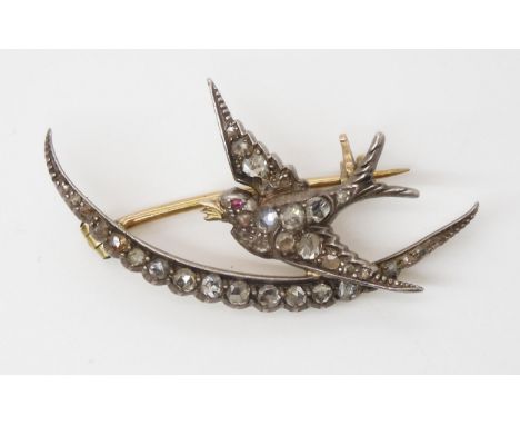 A DIAMOND SET SWALLOW AND MOON BROOCH the yellow and white metal mount set throughout in rose cut diamonds, with a ruby set t