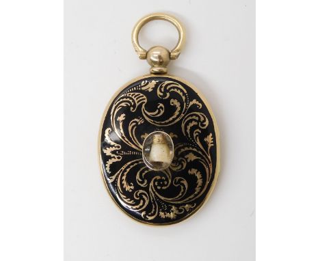 A VICTORIAN TOOTH &amp; HAIR MOURNING LOCKET in yellow metal with black champleve enamel decoration to the case. Inside the l