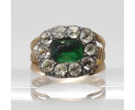 A GEORGIAN STYLE PASTE SET RING mounted in yellow and white metal and set with green and white glass gems in cut back setting