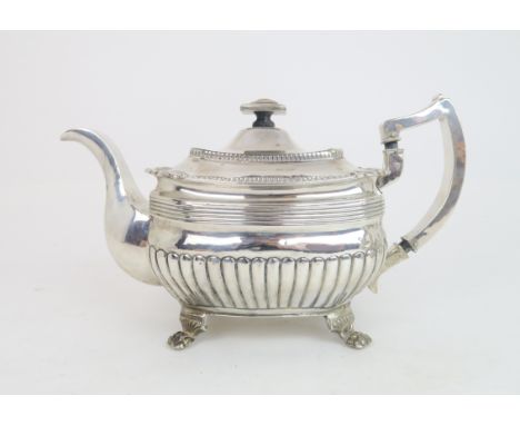 A GEORGE III IRISH SILVER TEAPOT of squat rectangular form, the body fluted with reeded rims, the lid with shellwork decorati