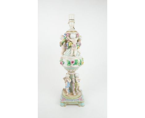 A CONTINENTAL PORCELAIN URN SHAPED LAMP decorated with putti with swags of flowers and applied roses, 54cm high Condition Rep