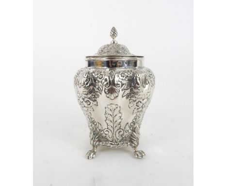 A LATE VICTORIAN SILVER TEA CADDY of bombe form, with repousse scrolling floral and shell decoration and engraving, with wryt