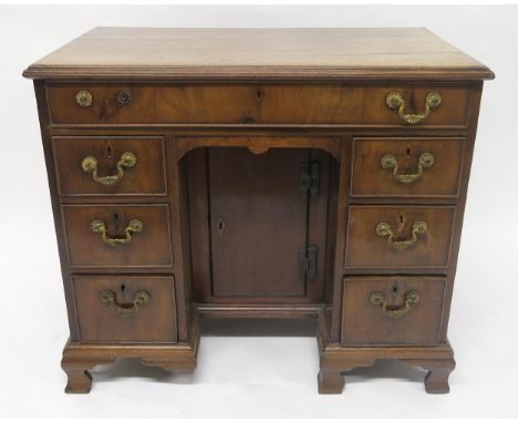 A GEORGIAN MAHOGANY AND WALNUT VENEERED KNEEHOLE DESK with one long drawer above two banks of three drawers flanking central 