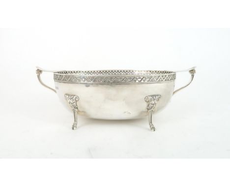 A GEORGE VI TWIN HANDLED SILVER BOWL in the Arts and Crafts style, with pierced floral fretwork borders, the body with a hamm