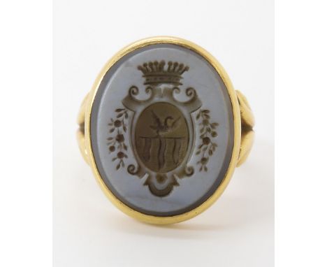 A BRIGHT YELLOW METAL INTAGLIO RING set with a carved sardonyx with a family crest featuring a swan. Finger size approx O, we