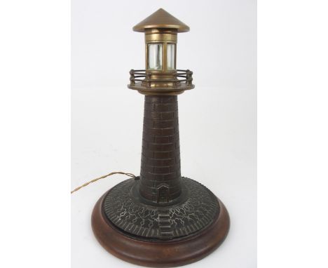A VINTAGE CAST BRASS LIGHTHOUSE TABLE LAMP fitted for electricity, on circular wooden base, 37cm high x 25cm wide&nbsp; Condi