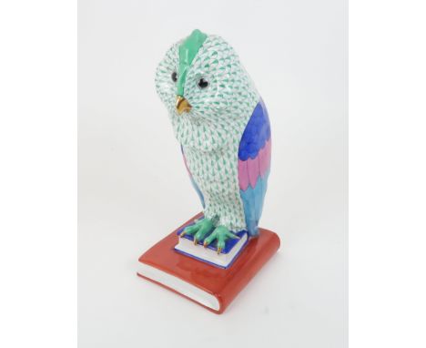 A LARGE HEREND PORCELAIN FIGURE OF AN OWL with green scale decoration, modelled seated on a pile of books, 31 cm high Conditi