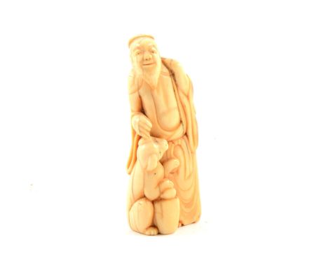 Carved ivory netsuke of an elder with dog, 8cm long.