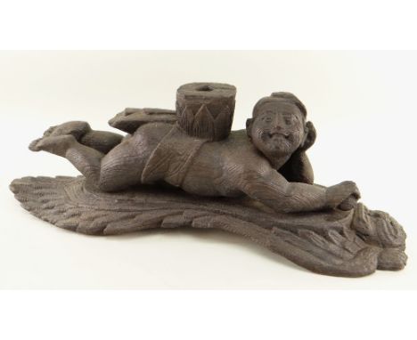 BURMESE CARVED WOOD ARCHITECTURAL FITTING carved as a figure recumbent on a winged deity or Nat, with socket in the back, 46c