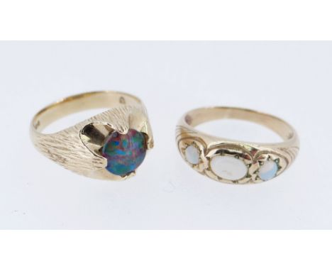 TWO 9CT GOLD OPAL RINGS comprising one set with single black opal triplet (size T) together with three stone opal ring (size 