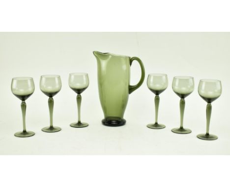 A collection of six mid 20th century smoked glass wine glasses, along with a matched pitcher jug. Each glass with rounded bow