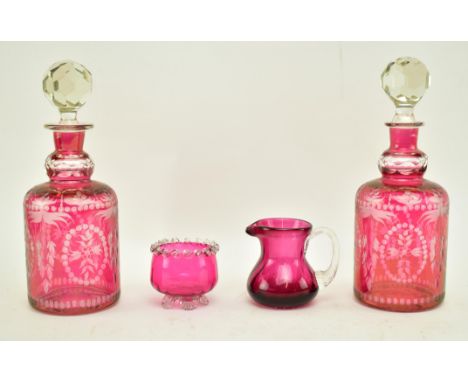 Four late 19th century &amp; early 20th century pieces of cranberry glassware. The lot comprising a cranberry pouring jug wit