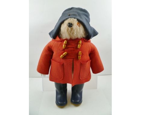 AN EARLY EDITION "PADDINGTON BEAR", wearing a red duffle coat and blue Dunlop Wellington boots, 45cm high 