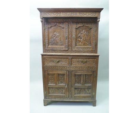 A 17TH CENTURY DESIGN OAK COURT CUPBOARD, the carved frieze monogrammed 'MJ', over two cupboard doors, with figurative panel 