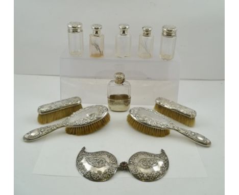 AN EDWARDIAN SILVER MOUNTED SPIRIT FLASK, having facet clear glass body, embossed twist cap and floral embossed removable cup