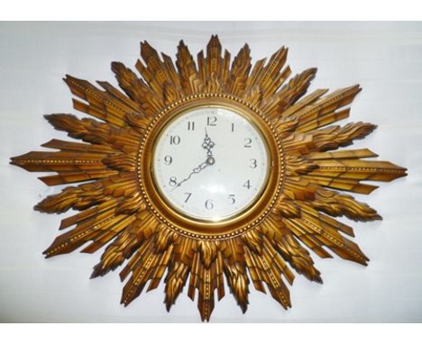 A SUNBURST DESIGN WALL CLOCK with Arabic numerals, overall 68cm wide 