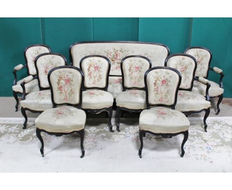 A LATE 19TH CENTURY FRENCH LOUIS XVI STYLE EBONISED SALON SUITE, comprising a three seater open arm canape (settee), four ope