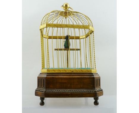 AN EARLY 20TH CENTURY FRENCH MUSICAL AUTOMATON BIRD CAGE, of decorative gilt metal construction, mounted upon a polished wood