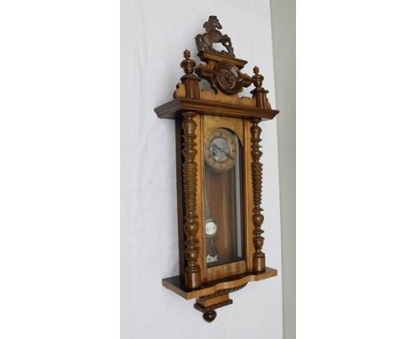 AN EARLY 20TH CENTURY WALNUT CASED VIENNA WALL CLOCK, with horse crest, 110cm high 