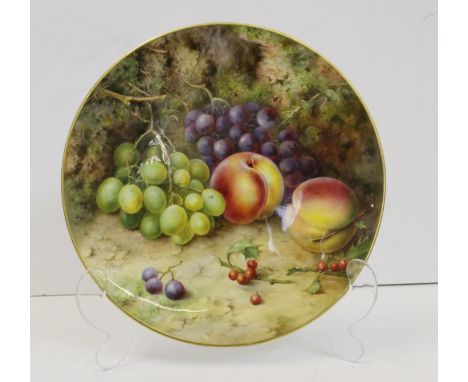 A Royal Worcester porcelain circular wall plaque, signed F.Roberts, painted with grapes, peaches and holly sprigs on a mossy 