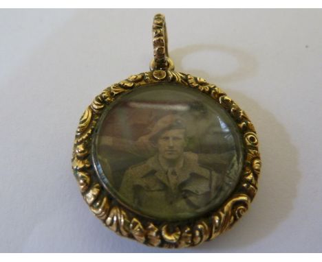 A mid 19thC yellow gold locket pendant of circular shape, the border finely carved and engraved with engine turned back
