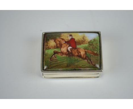 A 925 marked silver and enamel pill box, the cover with an enamelled plaque of a huntsman on horse taking a gate, stamped 925