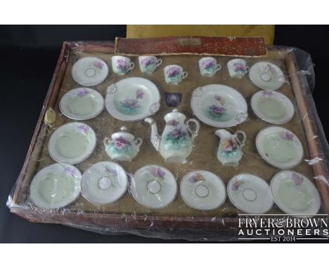 A French porcelain child's part breakfast service, decorated with pansy flowers, includes coffee pot, milk and sucrier cups, 