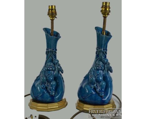 A pair of Japanese pottery figural vase lamp bases, the gourd form body with Daikokuten holding a hammer aloft; on gilded woo