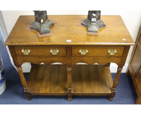 AN OAK SIDE TABLE, with two drawers, shaped front apron, turned front supports and lower shelf, approximate size width 96cm x