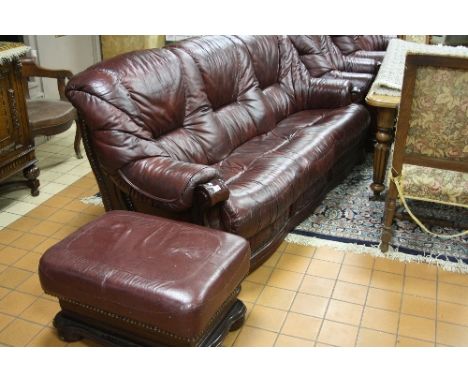 A BURGUNDY FOUR PIECE SUITE, comprising three seater settee, two seater settee, single armchair and a pouffe, together with a