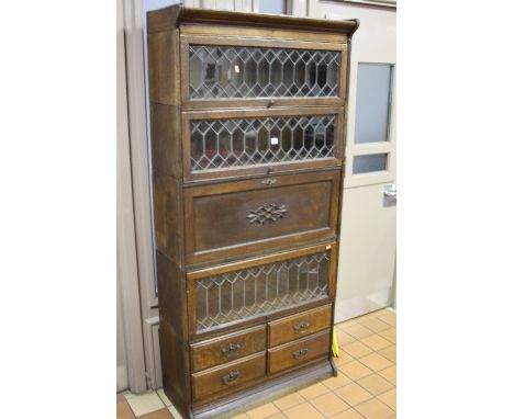 A 'GLOBE WERNICKE' STYLE LEAD GLAZED FIVE SECTION BOOKCASE, the central section with solid front and the lower section with f