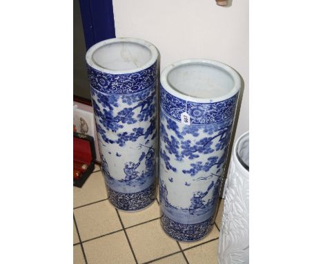 A LARGE PAIR OF CYLINDRICAL VASES/STICK STANDS, decorated in blue and white with figures in landscapes, floral and scroll str