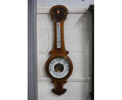 A CARVED OAK ANEROID BAROMETER