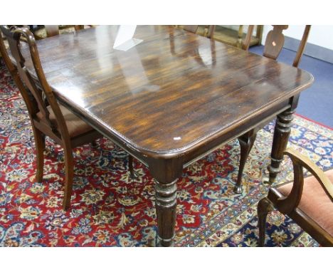 A 19TH CENTURY MAHOGANY DINING TABLE, with turned tapering supports and white ceramic castors, approximate size length 150cm 
