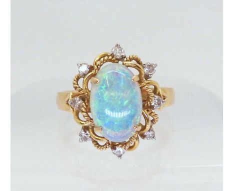 AN OPAL AND DIAMOND RING set with an oval opal of approx 11.1mm x 7.3mm x 2.5mm, and diamond accents to the 14k gold mount, f