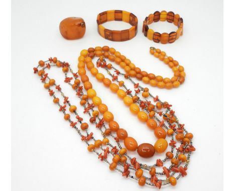 A GROUP OF AMBER COLOURED JEWELS a string of butterscotch colour beads, largest 19.3mm x 16.1mm, to smallest 9.4mm x 6.9mm, l