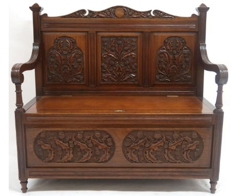 AN EARLY 20TH CENTURY SCOTTISH HALL SETTLE&nbsp; with three panel back rest carved with thistle motifs flanked by carved scro