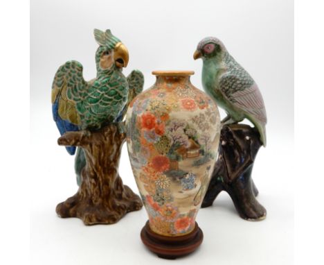 A Japanese export porcelain parrot, decorated in shades of blue, green and pink, modelled on a naturalistic trunk, another ex