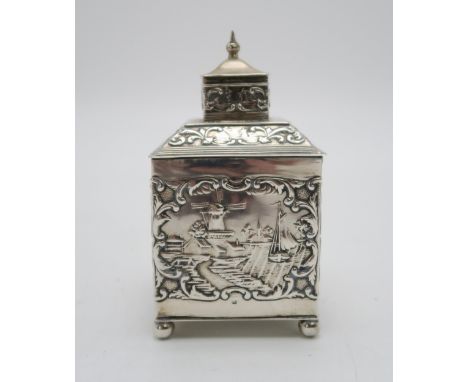 A DUTCH EXPORT SILVER TEA CADDY of cuboid form, the body with repousse and chased decoration of rural harbour scenes within s
