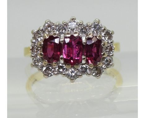 A RUBY AND DIAMOND RING set with three rubies, largest approx. 6mm x 3.7mm x 2.6mm, smaller approx. 5.5mm x 3.5mm x 2.2mm. Th