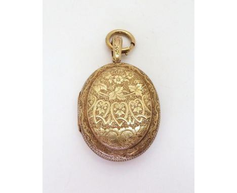 A VICTORIAN LOCKET engraved on both sided with ferns, roses and hearts, with a small monogrammed shield, made in un-hallmarke