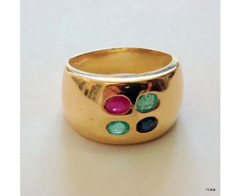 A yellow metal emerald, ruby and sapphire ring