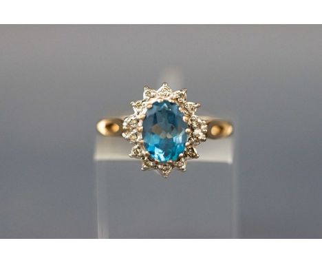 A 9ct gold, blue topaz and diamond oval cluster ring, London 1988, size K, 2.3 grams gross