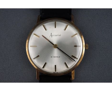 A 9ct yellow gold cased Accurist wristwatch having a circular silver baton dial. 17 Jewel manual wind movement with black lea