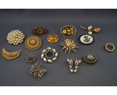 Fifteen vintage costume jewellery brooches including: a gilt metal rose; an imitation pearl circlet; a damascened oval panel 