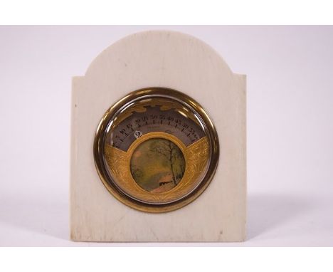 An early 20th century French ivory desk clock, the unusual aperture within an engraved gilt metal surround and a watercolour 