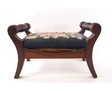 A 19th century mahogany footstool with turned handles, reeded legs and tapestry upholstery, 39cm wide