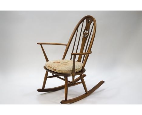 An Ercol stick back rocking chair, the splat with carved swan detail