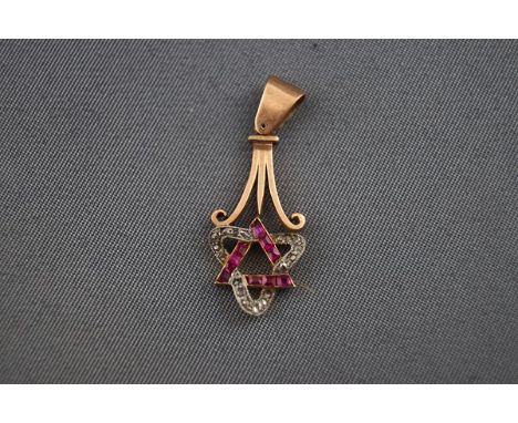 An early 20th century rose gold, ruby and diamond pendant, in the form of an entwined ruby triangle and a tri-form diamond sc