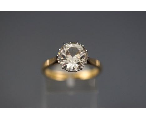 A yellow and white metal single stone ring claw set with a 10mm colourless Zircon. Stamped 18ct Plat. Size: R 4.9 grams